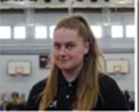 A woman with curly hair is smiling and wearing a white tank top.