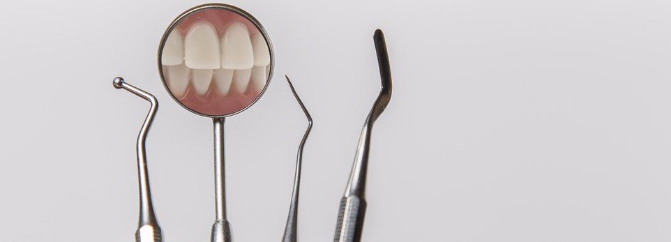 degli strumenti da dentista con riflesso dei denti
