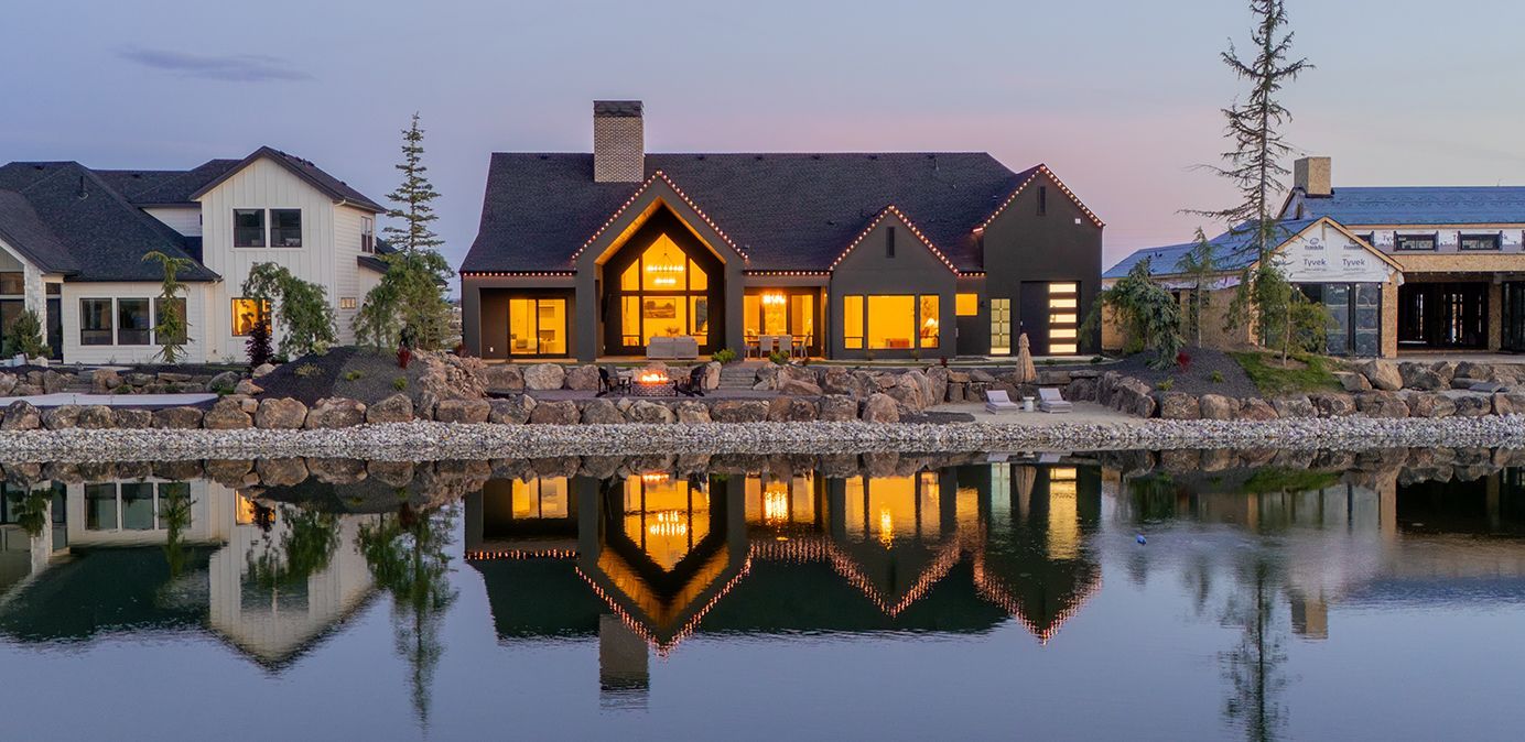 A large house is sitting on the shore of a lake.