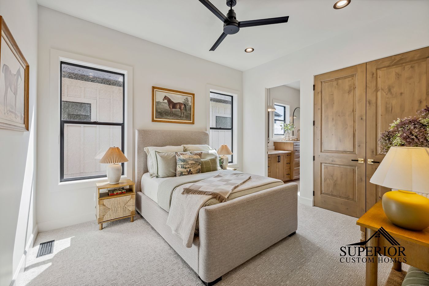 A bedroom with a large bed and a ceiling fan.
