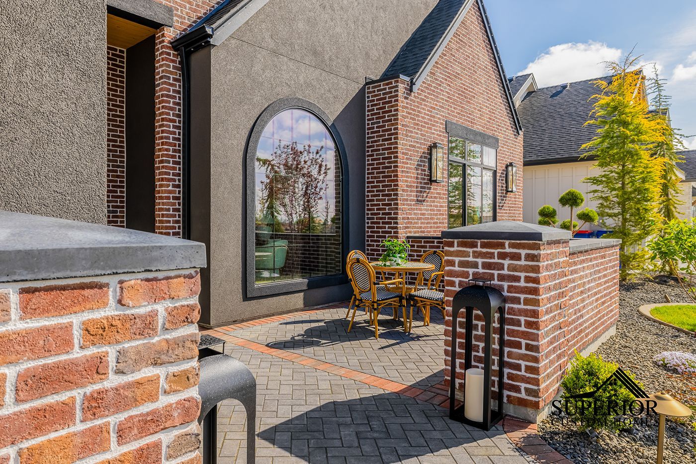 A brick house with a patio and a table and chairs in front of it.