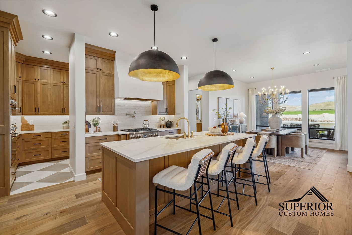 A kitchen with a large island and stools in a house.