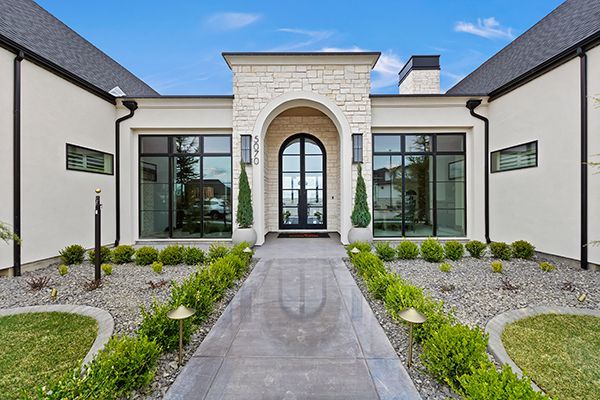 A large white house with a walkway leading to the front door.