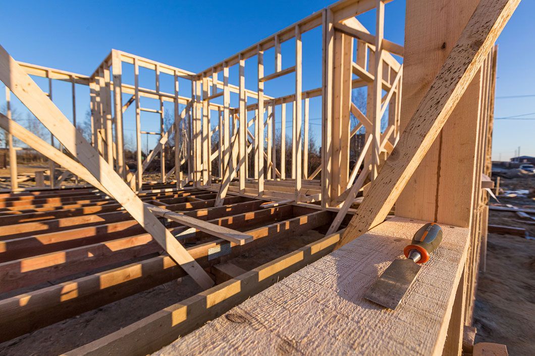 A wooden house is being built on a construction site.