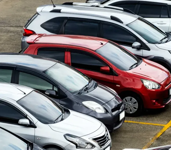 A row of cars are parked in a parking lot.