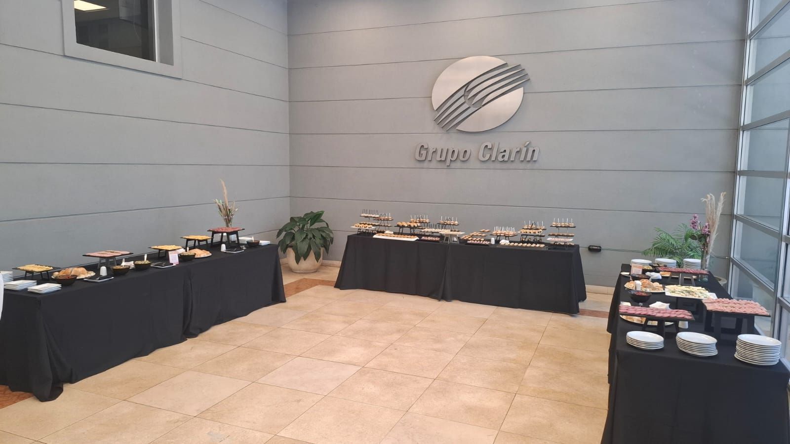 Mesas buffet con comida en una sala con el logo “Goya Marín” en la pared.