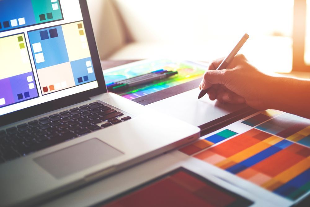 A Person is Using a Pen to Draw on a Laptop Computer — Sign Media Solutions in Ballina, NSW