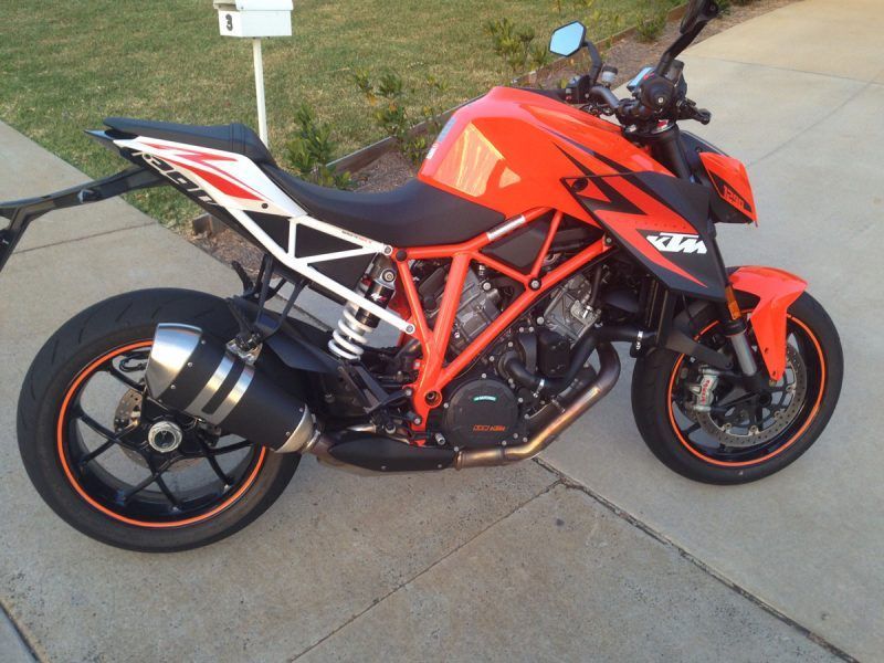 A Red and Black Motorcycle is Parked on a Sidewalk — Sign Media Solutions in Ballina, NSW