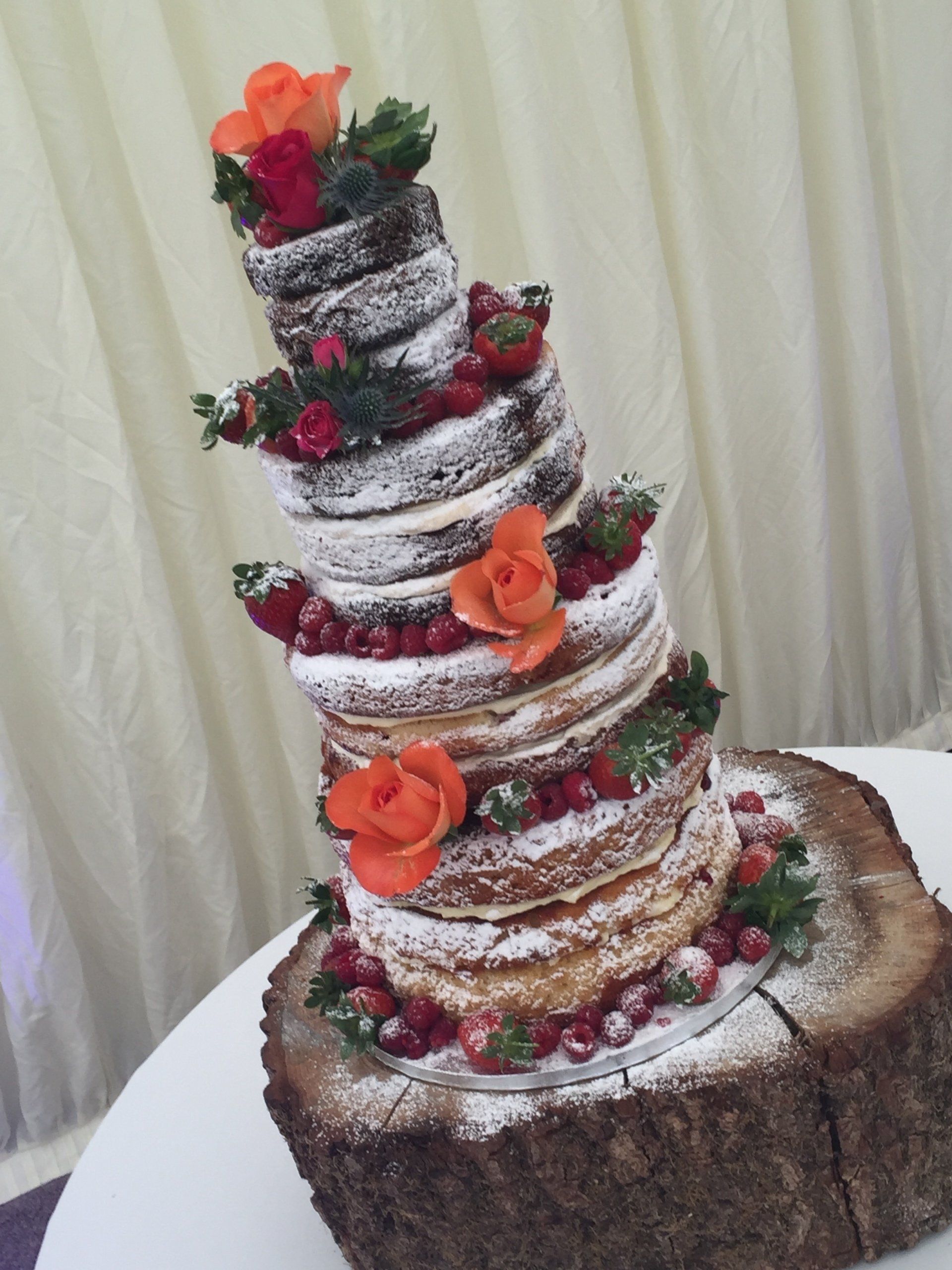 naked wedding cake with berries and flowers