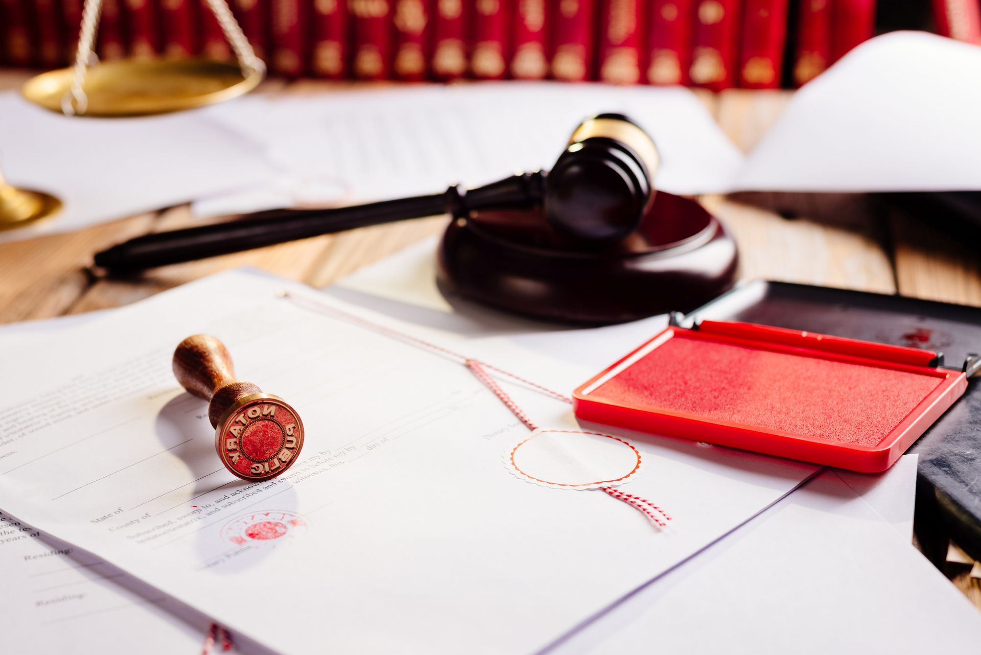 Gavel, scales, and seal stamp on legal documents, implying a courtroom or law setting.