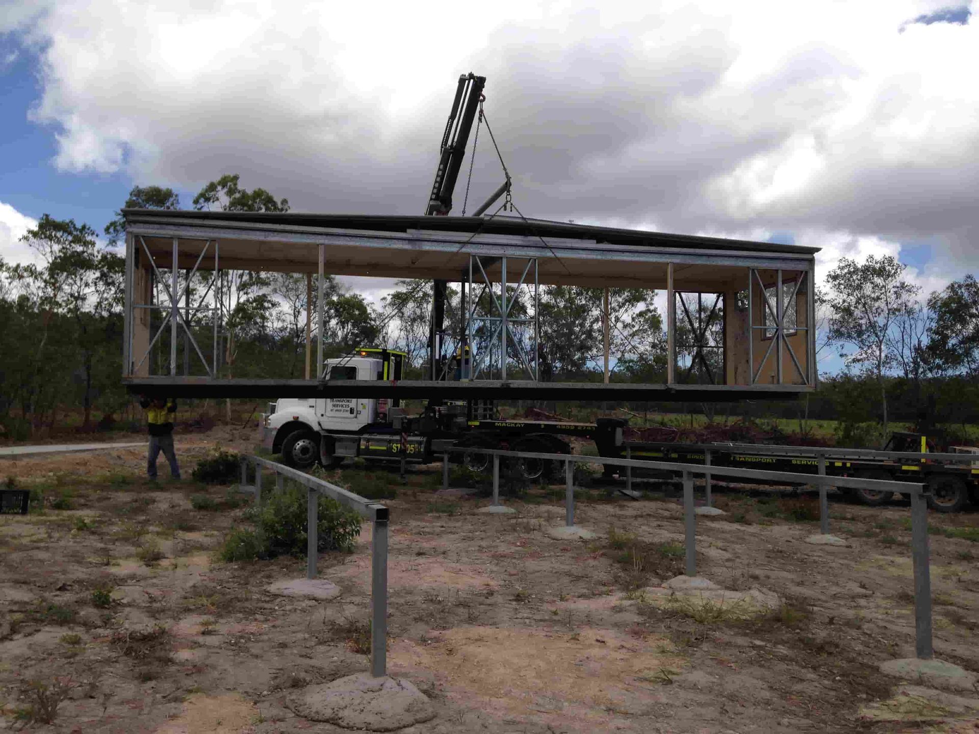A Crane Is Lifting A House Into The Air — Single Transport Services In Palmyra, QLD