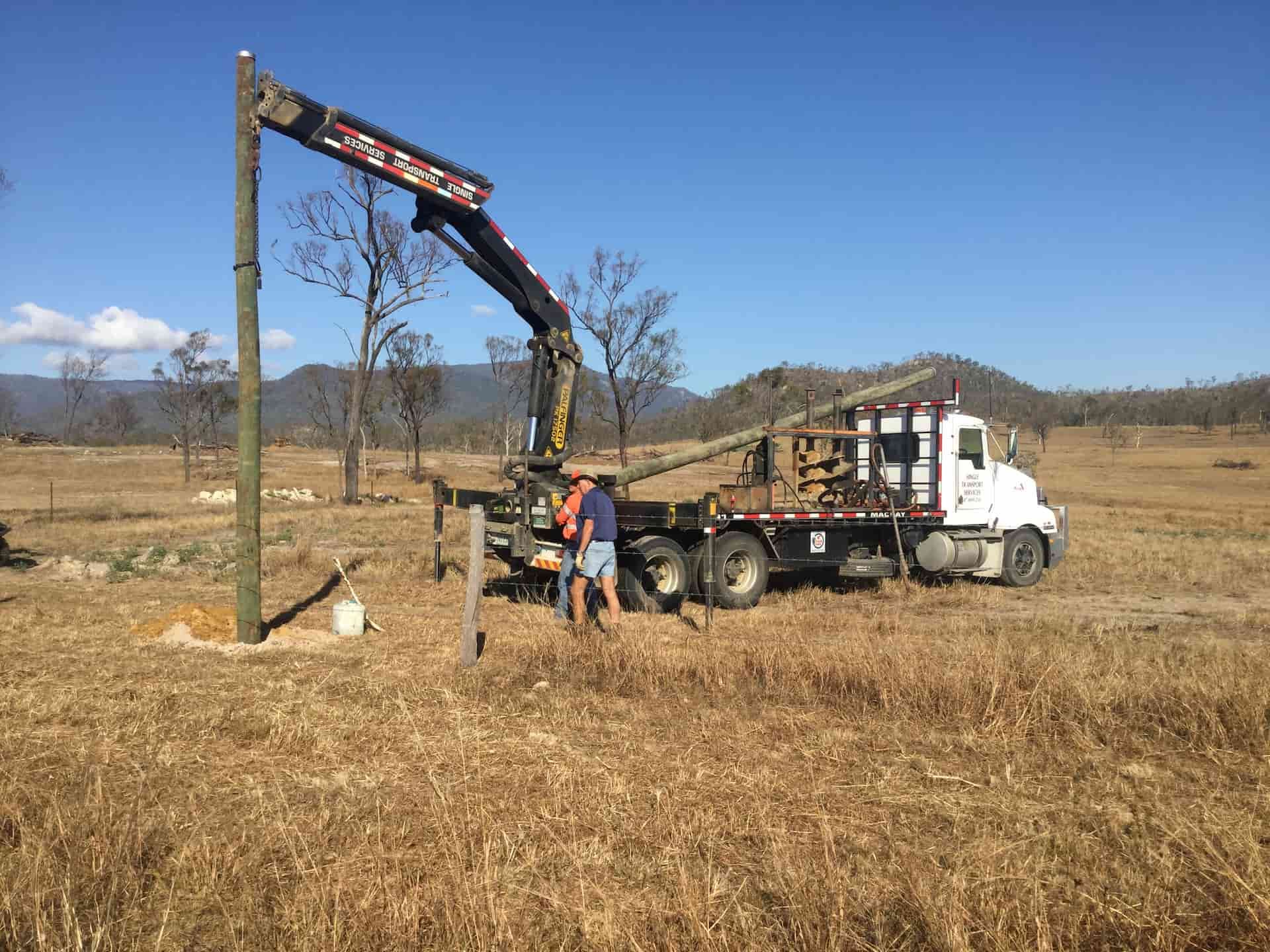 A Truck Is Parked In A Field With A Crane Attached To It — Single Transport Services In Palmyra, QLD