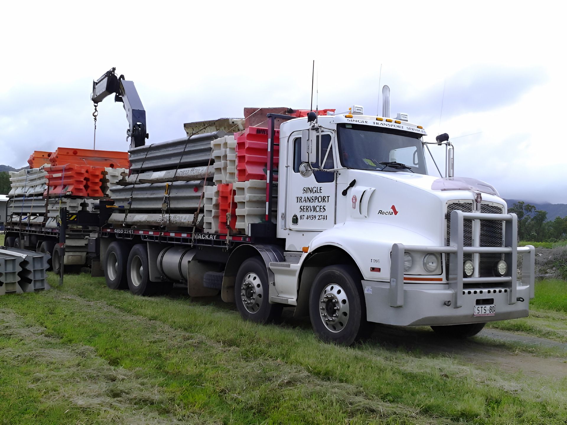 A Truck With A Crane Attached To It Is Carrying A Container — Single Transport Services In Palmyra, QLD