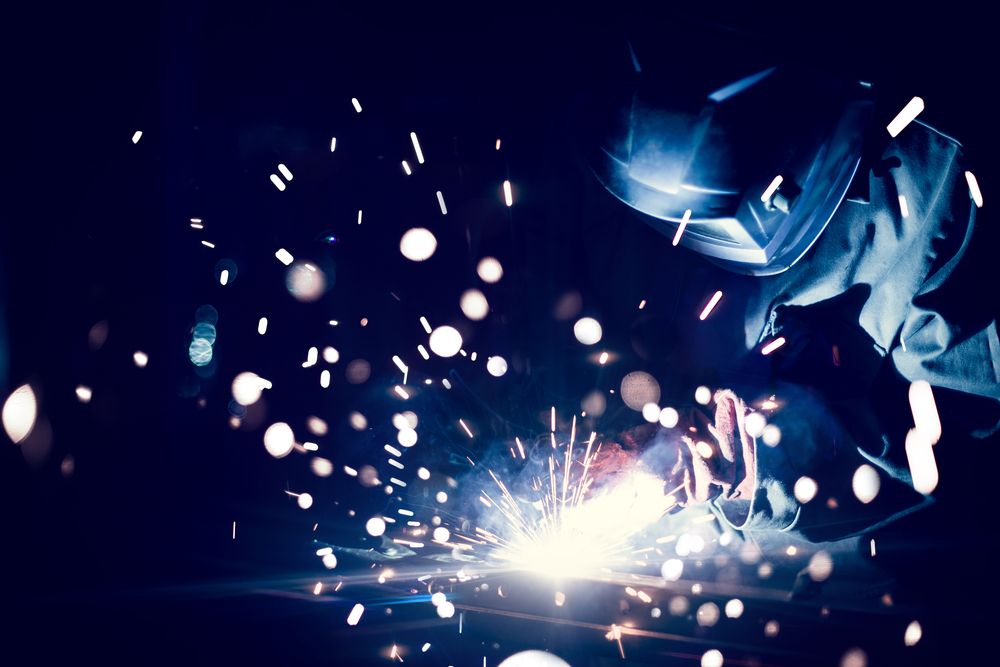 Employee Welding Steel With Sparks Using Mig Mag Welder — Bowen Hire & Sales in Bowen, QLD