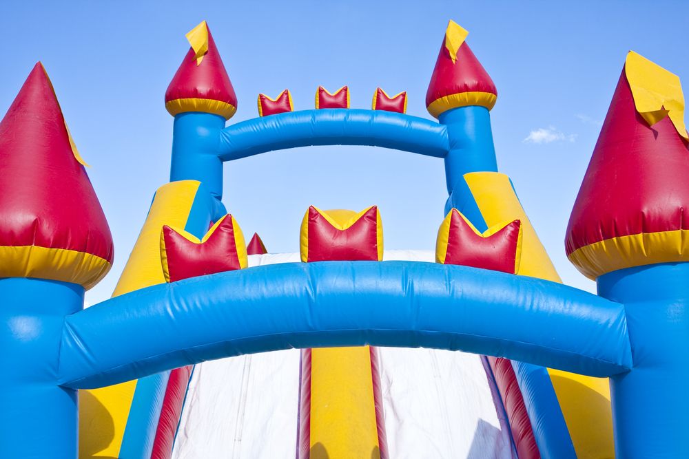 A Red , Yellow and Blue Bouncy Castle With a Blue Sky in the Background — Bowen Hire & Sales in Bowen, QLD