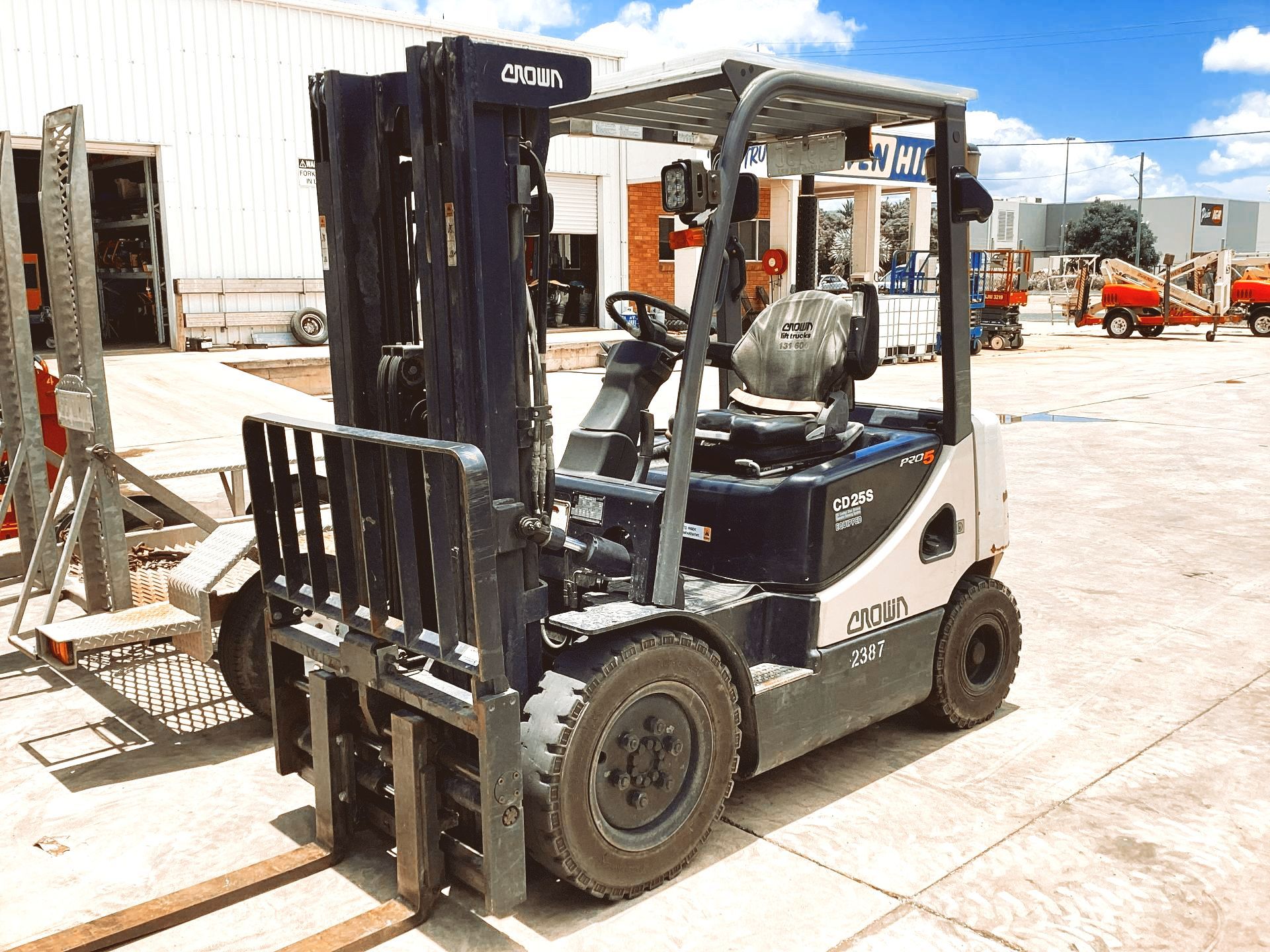 A Forklift is Parked in a Parking Lot in Front of a Building — Bowen Hire & Sales in Bowen, QLD