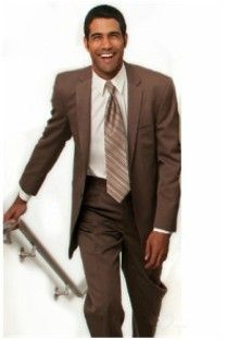 A man in a brown suit and tie is walking down stairs