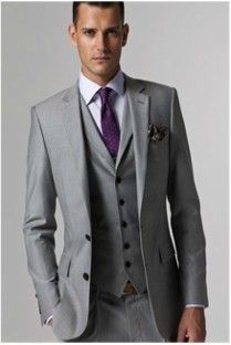 A man in a grey suit and purple tie