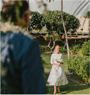 A woman in a white dress is walking towards a man in a blue shirt
