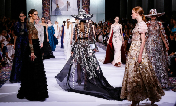 A group of models are walking down a runway at a fashion show