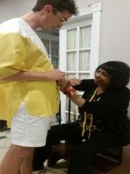 A man is standing next to a woman in a yellow robe.