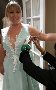 A woman is getting her dress altered by a tailor.