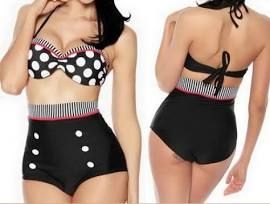 A woman is wearing a black and white polka dot bikini.