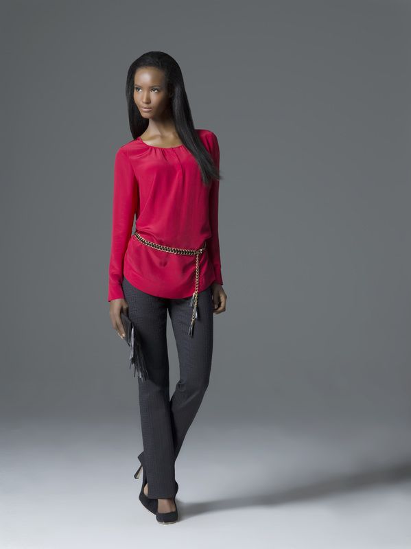 A woman is wearing a red top and black pants