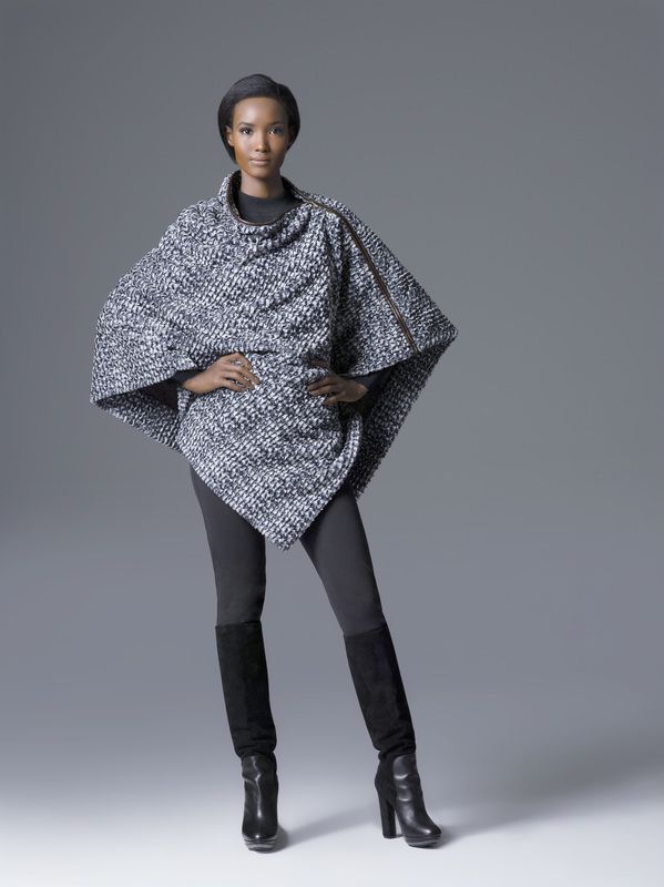 A woman wearing a grey poncho and black boots