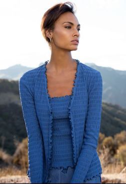 A woman is wearing a blue cardigan and a blue top