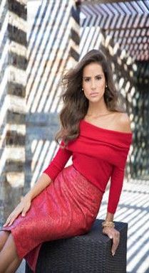 The woman is wearing a red off the shoulder top and a red skirt.