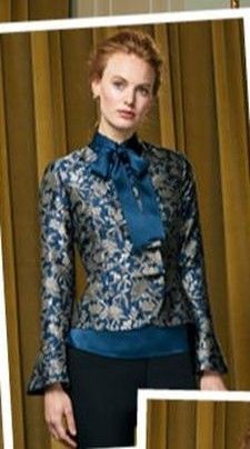 A woman is wearing a blue jacket with a bow on the neck.