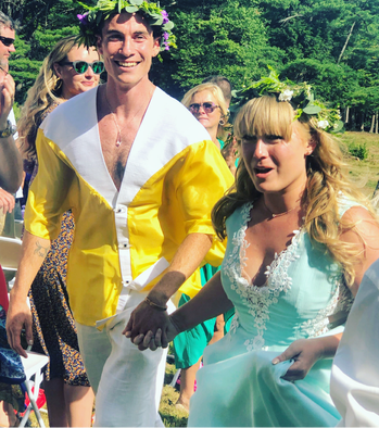 A man in a yellow shirt is standing next to a woman in a blue dress