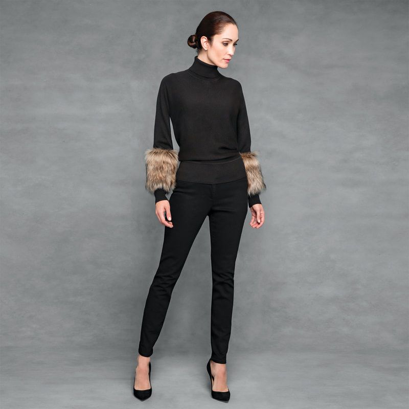 A woman wearing a black sweater with fur sleeves