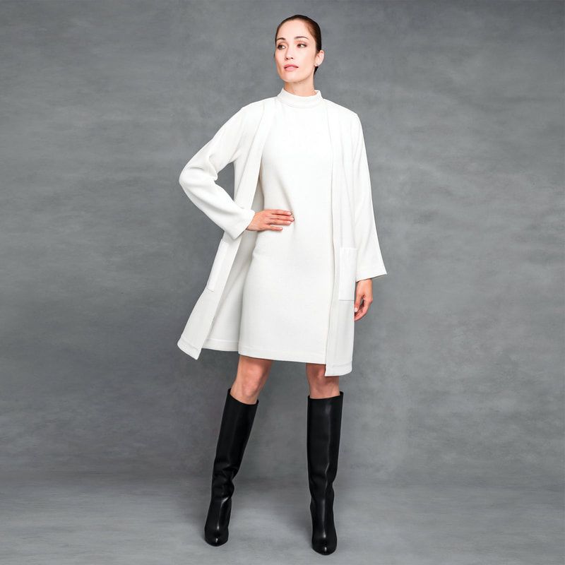 A woman wearing a white dress and black boots