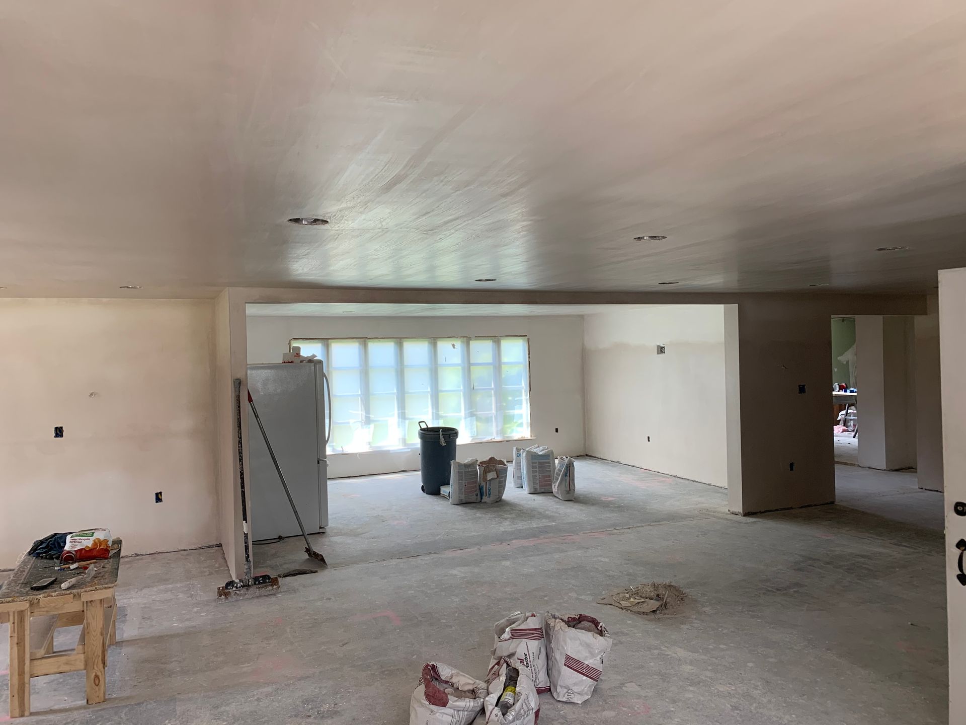 A large empty room with a lot of bags on the floor.