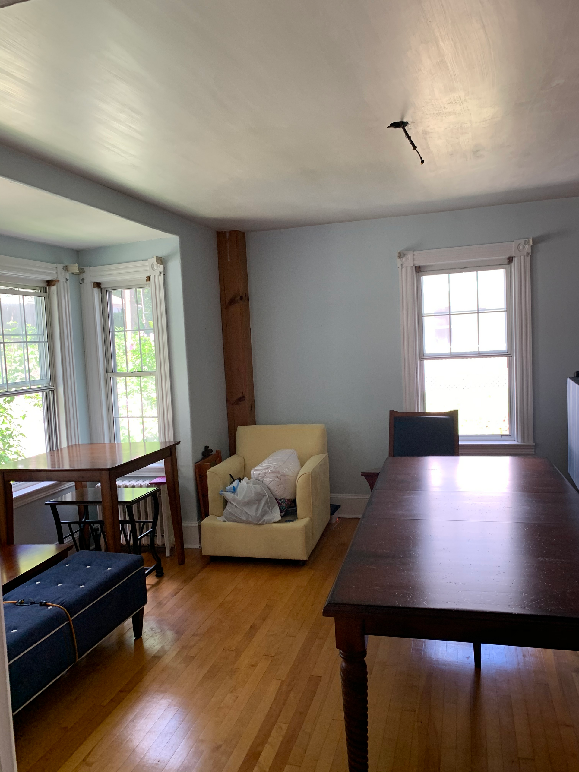 A living room with a table and chairs and a window.