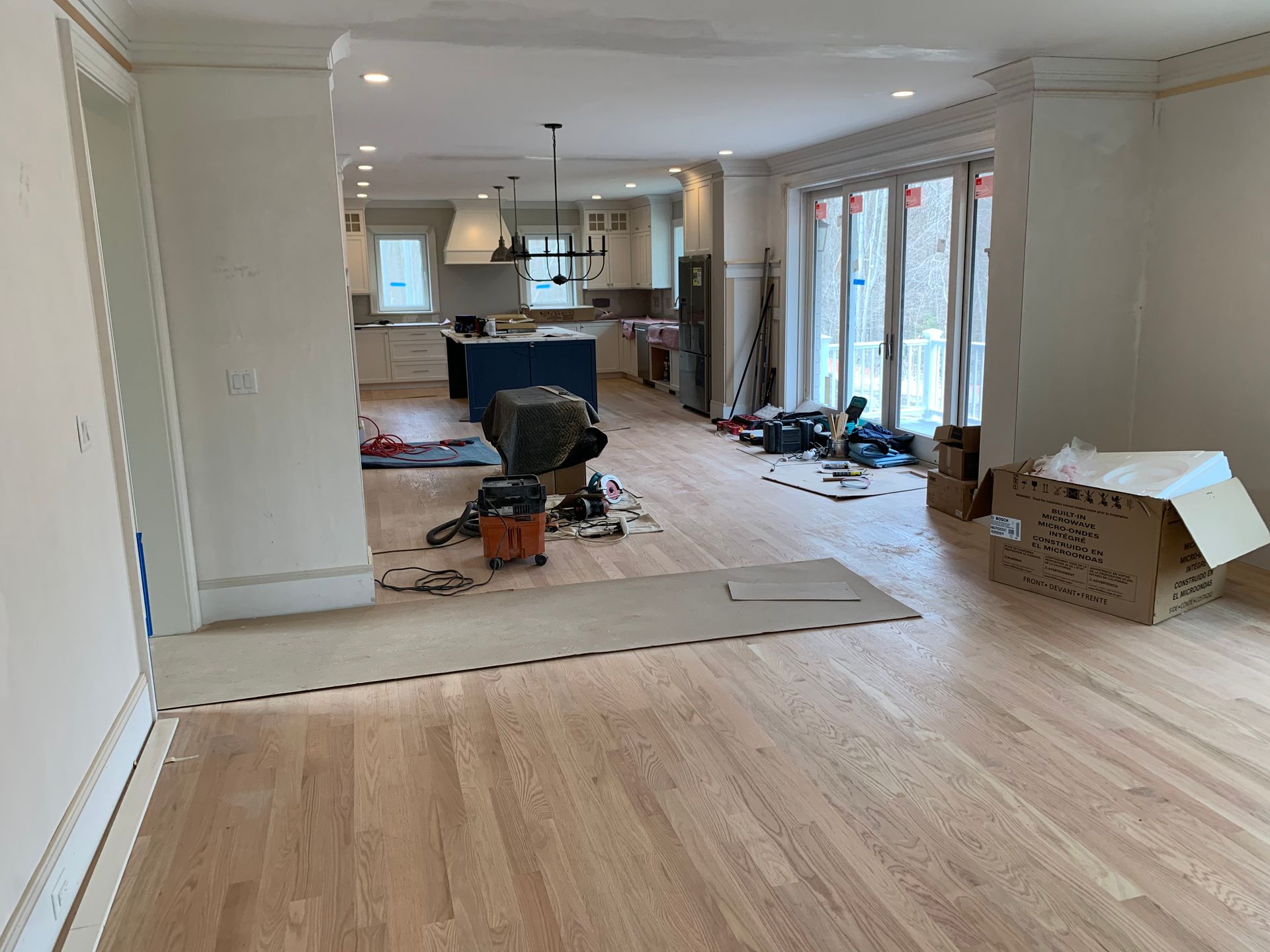 A large room with hardwood floors and a vacuum cleaner in it.