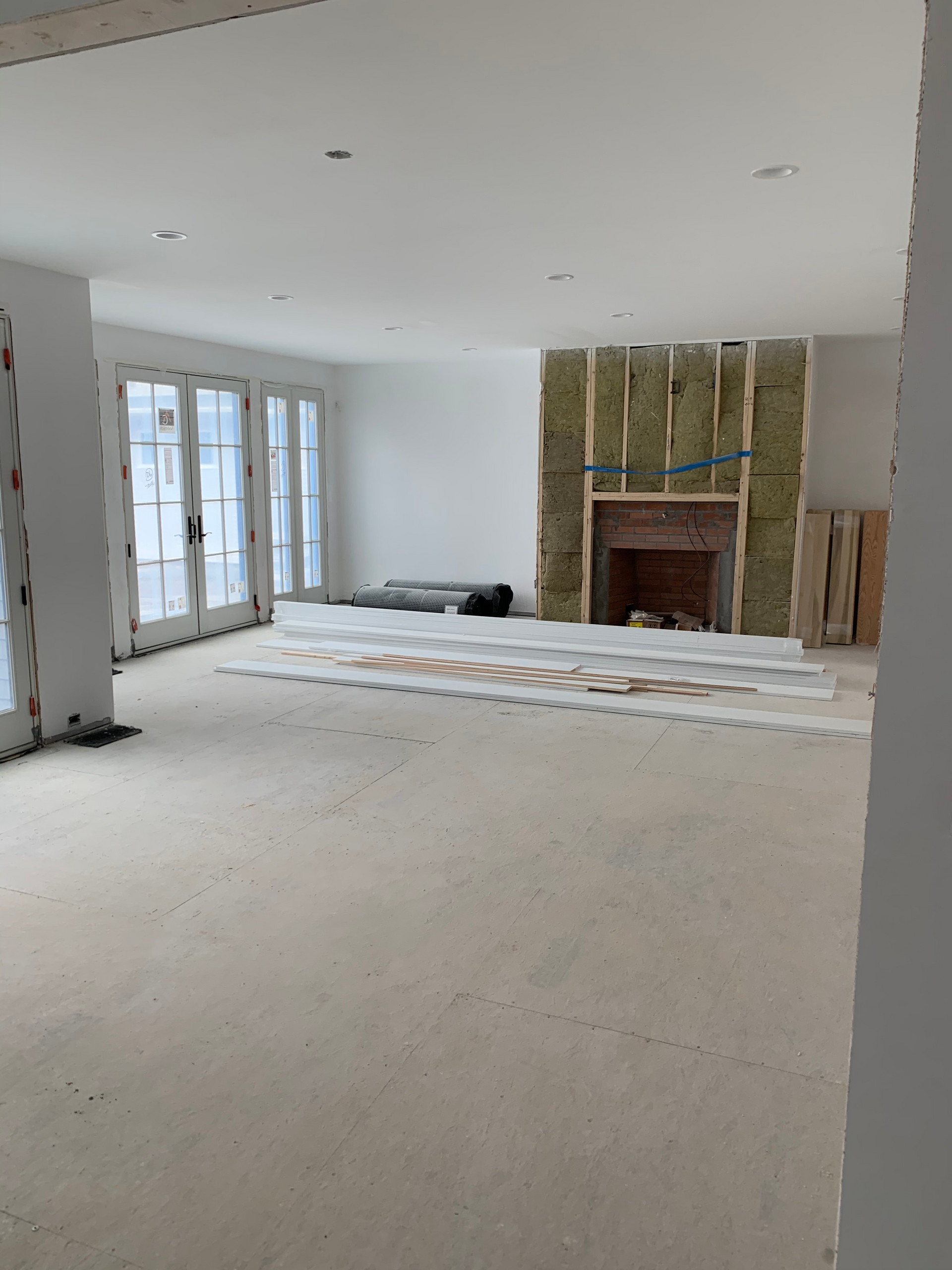An empty room with a fireplace and sliding glass doors