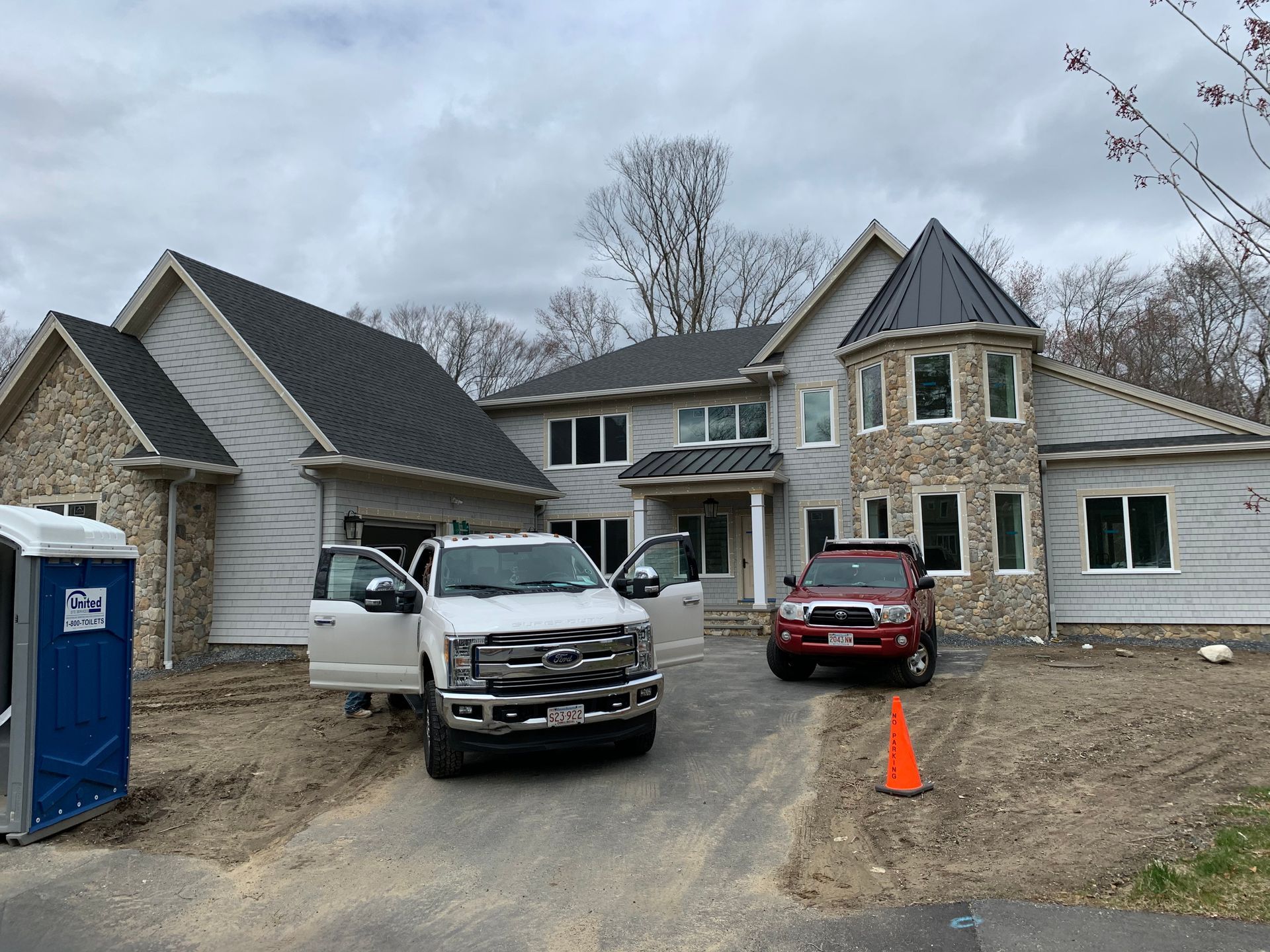 Two trucks are parked in front of a large house.