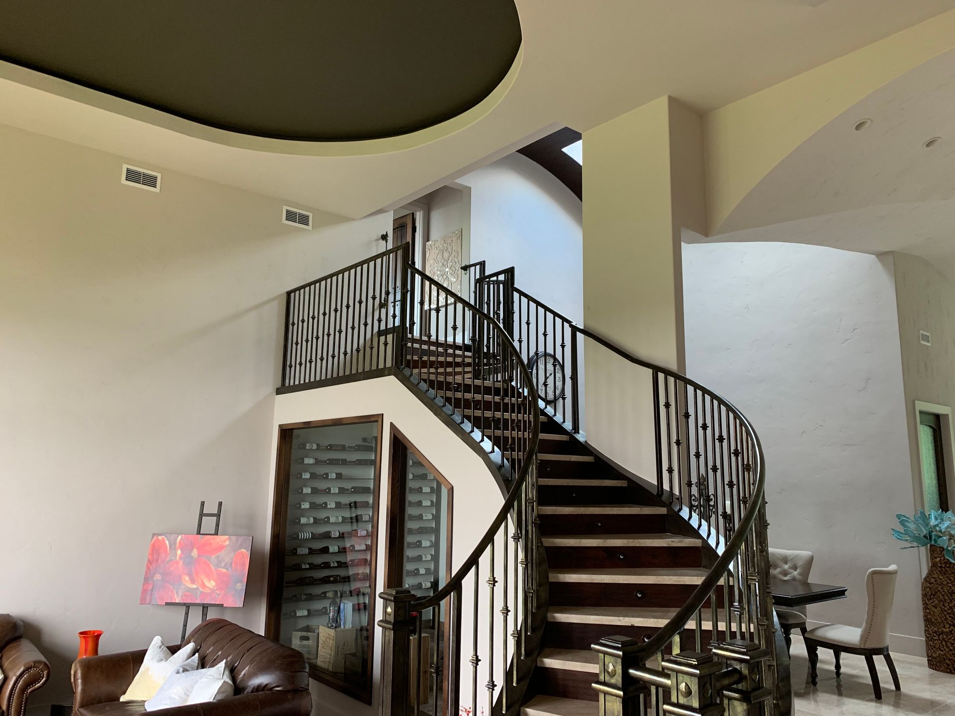 A living room with a spiral staircase leading up to the second floor