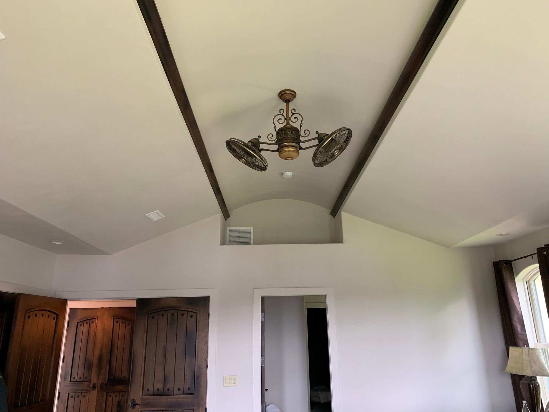 A living room with a vaulted ceiling and a ceiling fan