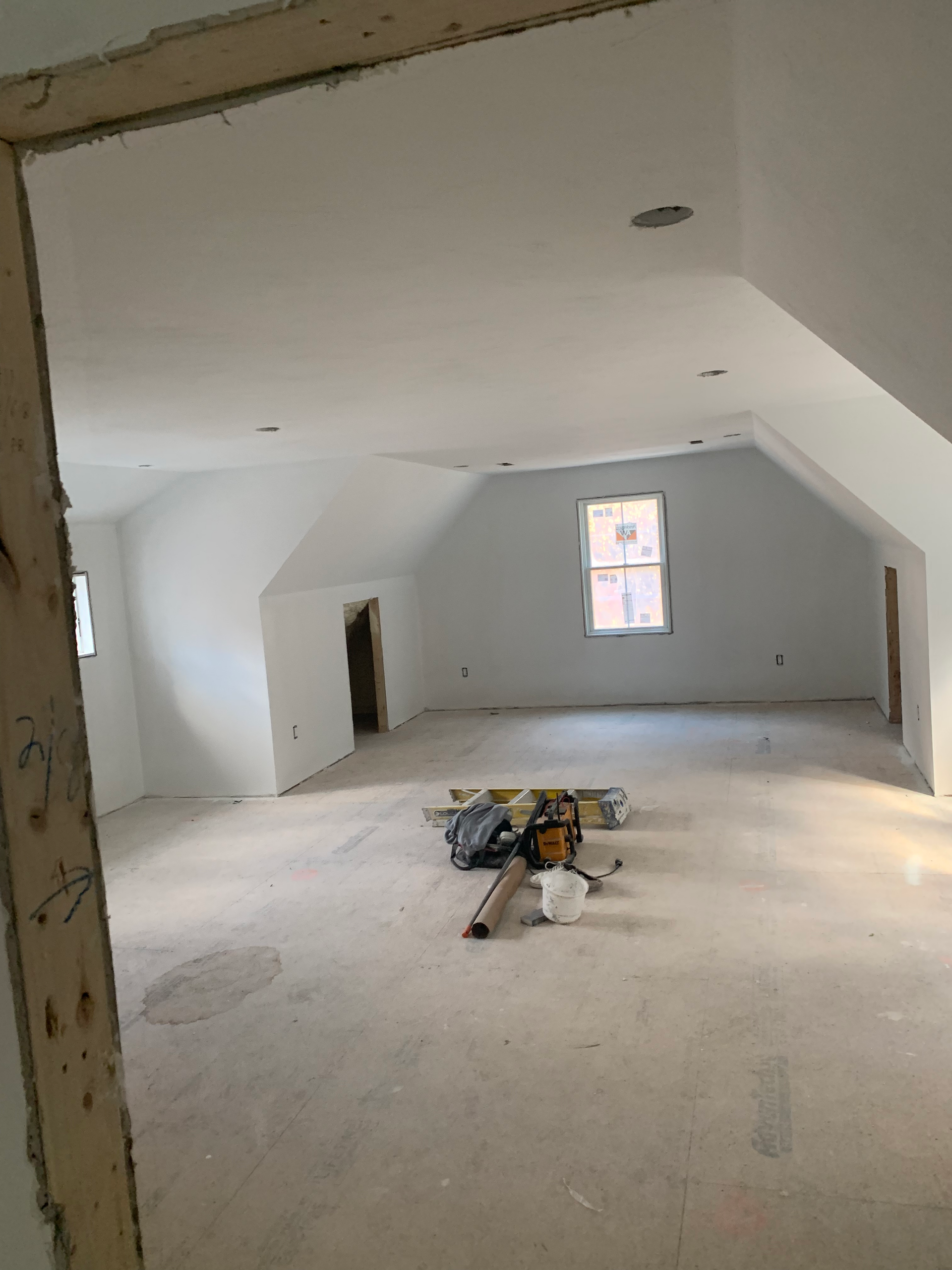 A large empty room with a window in the corner.