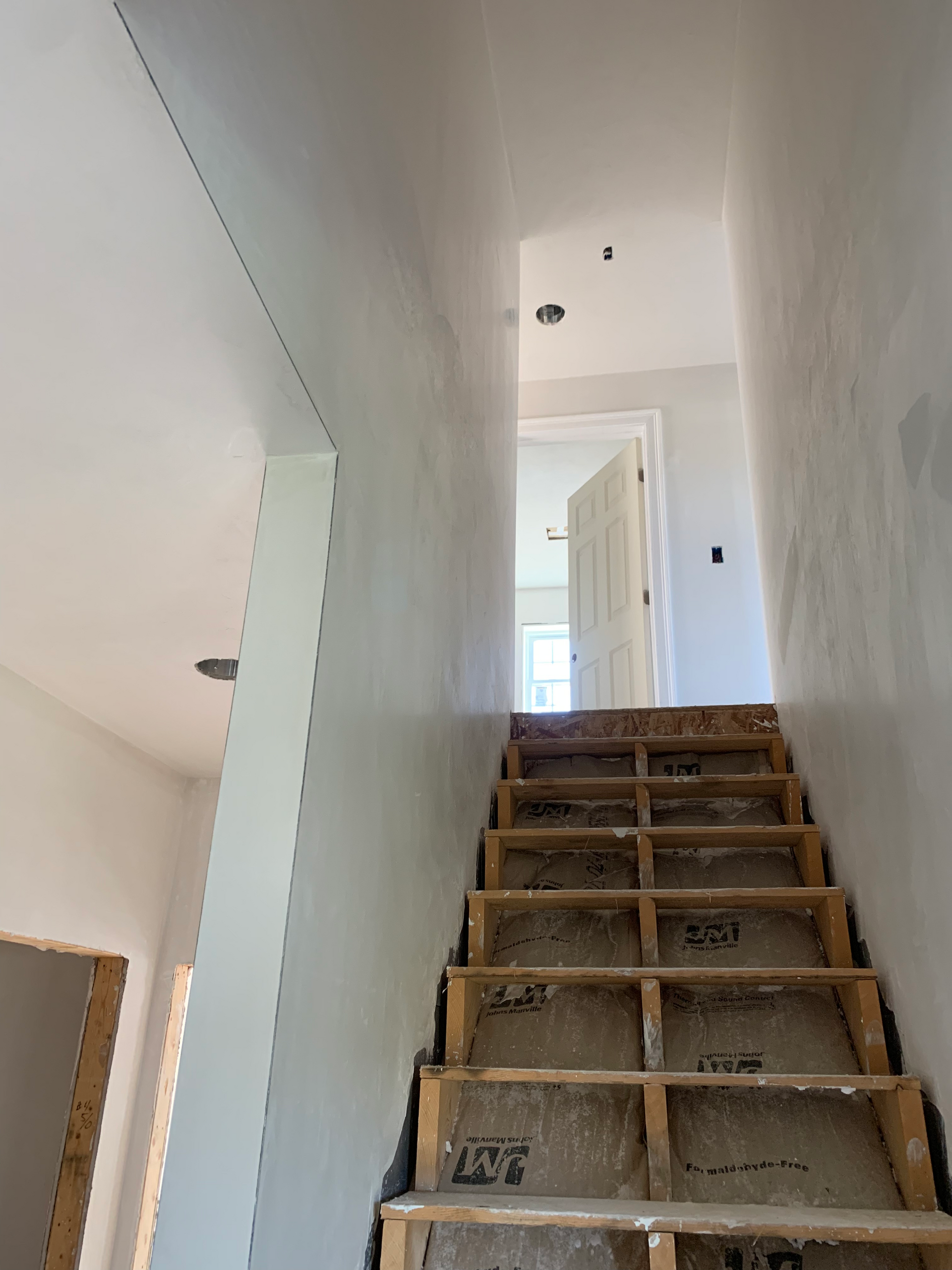 A wooden staircase is being built in a house.