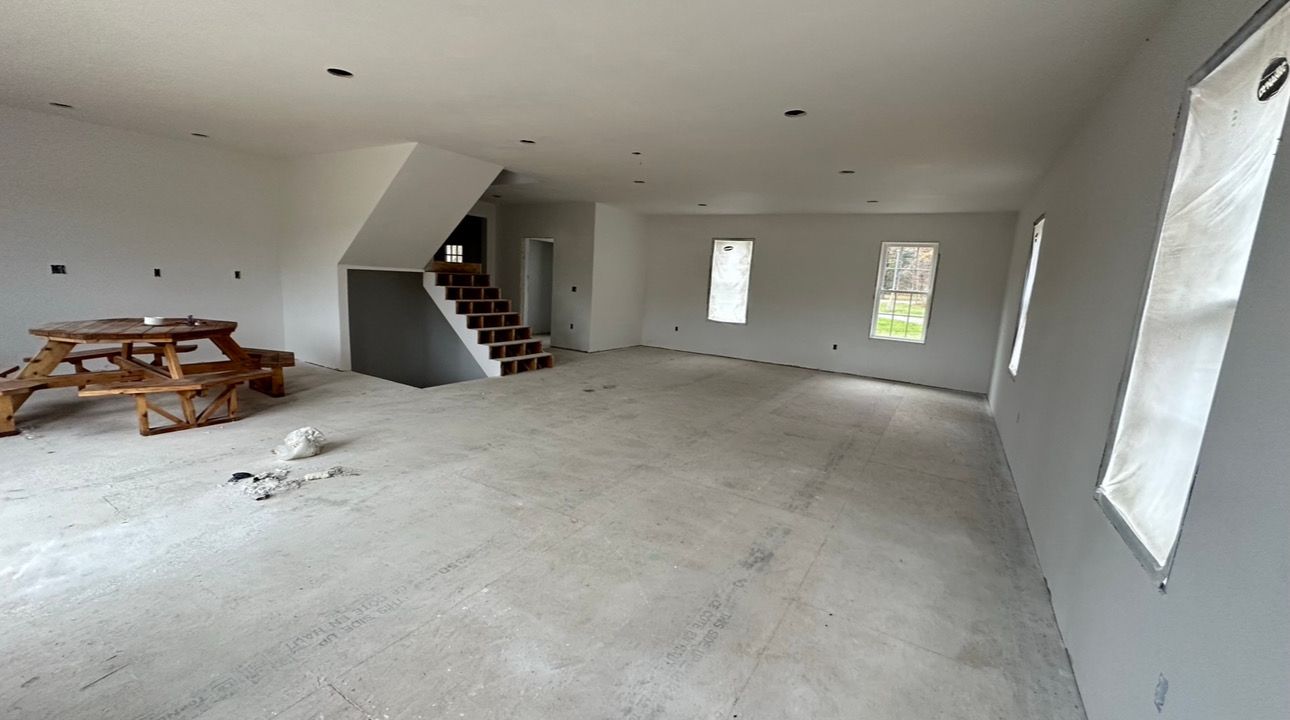 An empty room with a picnic table and stairs