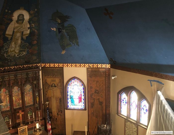 A church with a blue ceiling and stained glass windows