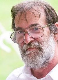 Man with a gray beard and glasses, looking at the camera.