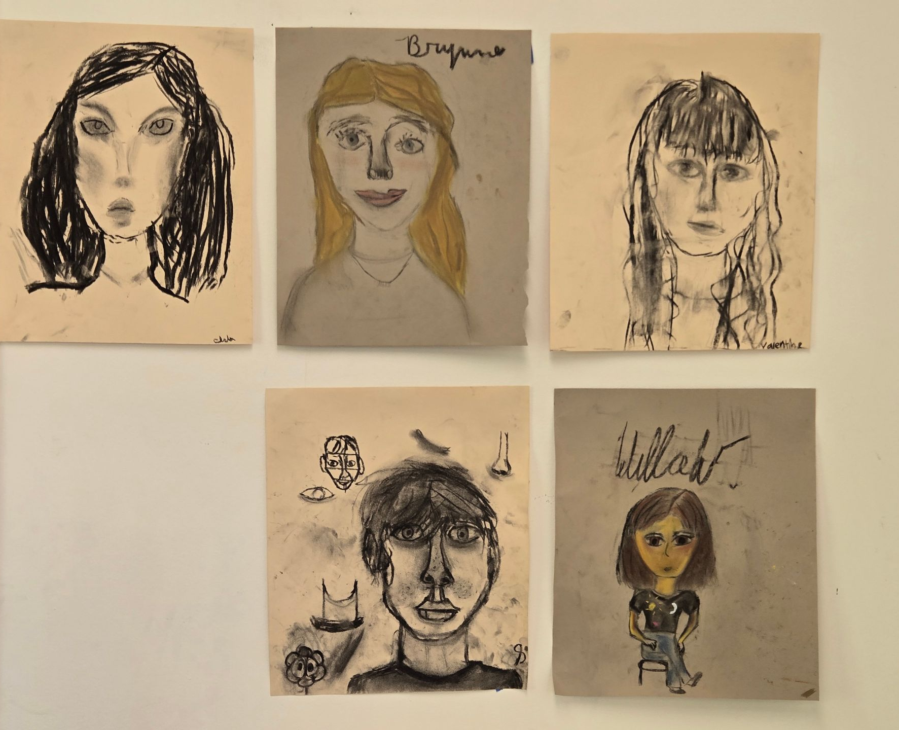 Five portraits, charcoal and crayon on tan paper. Subjects are young people; some smiling.