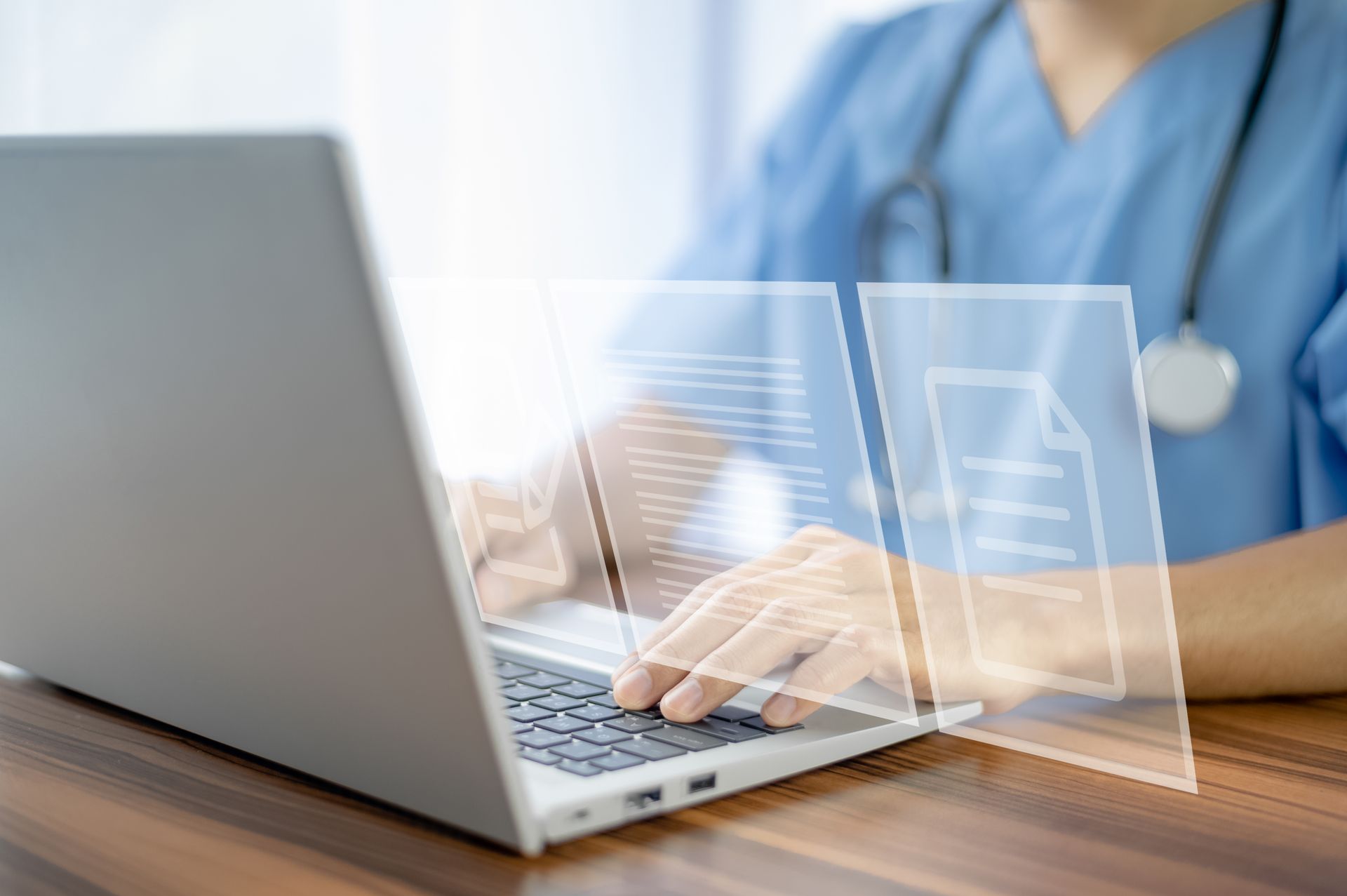 A nurse is typing on a laptop computer with a stethoscope around her neck.