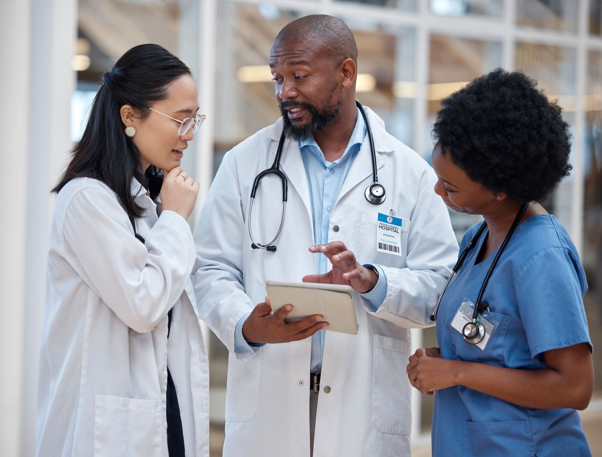 A group of doctors are looking at a tablet together